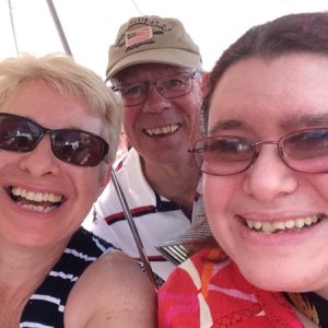 Image of Emma Purcell, blog author and CripLife co-founder with her parents, all smiling.